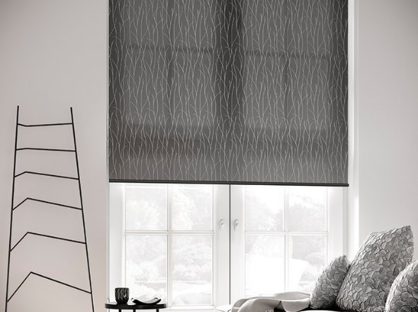 A black roller blind in a living room window with abstract art on the wall