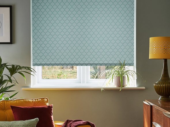 A blue diamond patterned roller blind in a living room with mustard yellow accents and plants