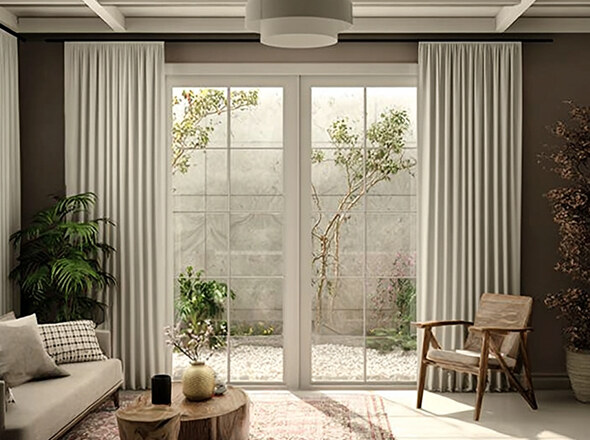 A light sheer curtain framing glass doors with white frames in an open plan living space