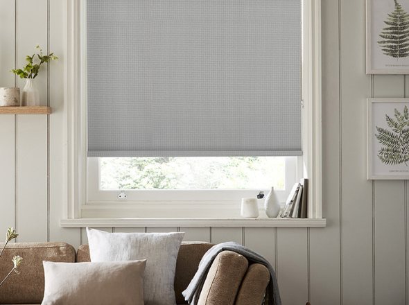 A stylish grey roller blind in a chic modern living room
