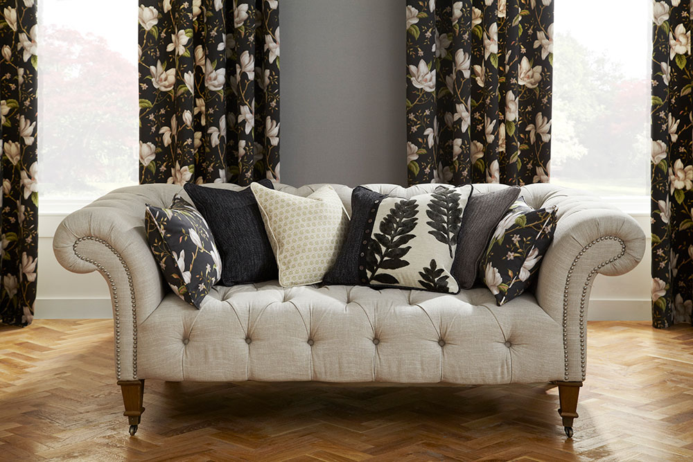 Cream floral curtains and cushions set on a black background.