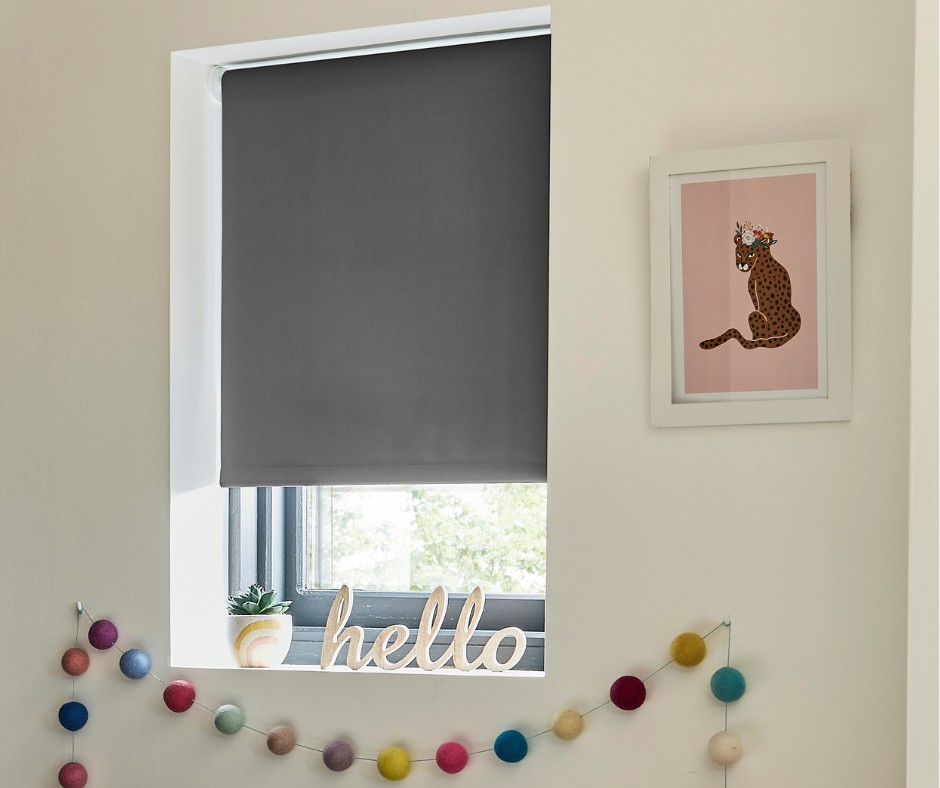 A grey blackout blind in a kids bedroom window