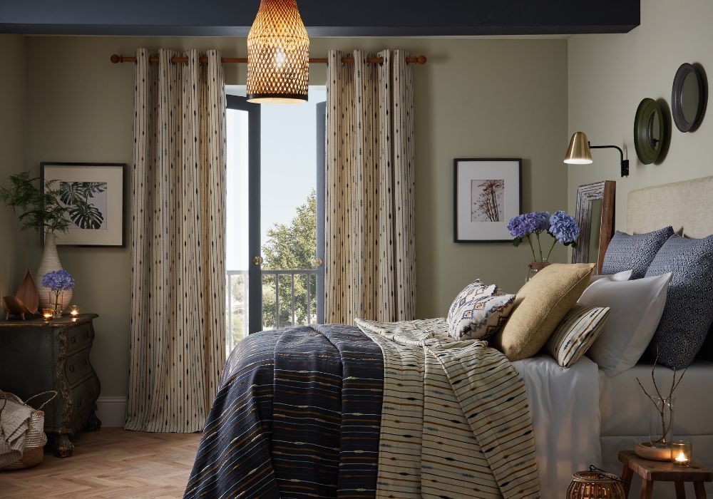 A bright bedroom with french patio doors dressed with spotted curtains